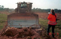 A clearly marked Rachel Corrie, holding a megaphone, confronts an Israeli bulldozer driver.